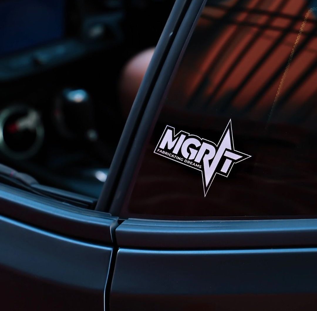 MGRIT 'Fabricating Dreams' logo displayed on a car window, showcasing custom branding for automotive enthusiasts.
