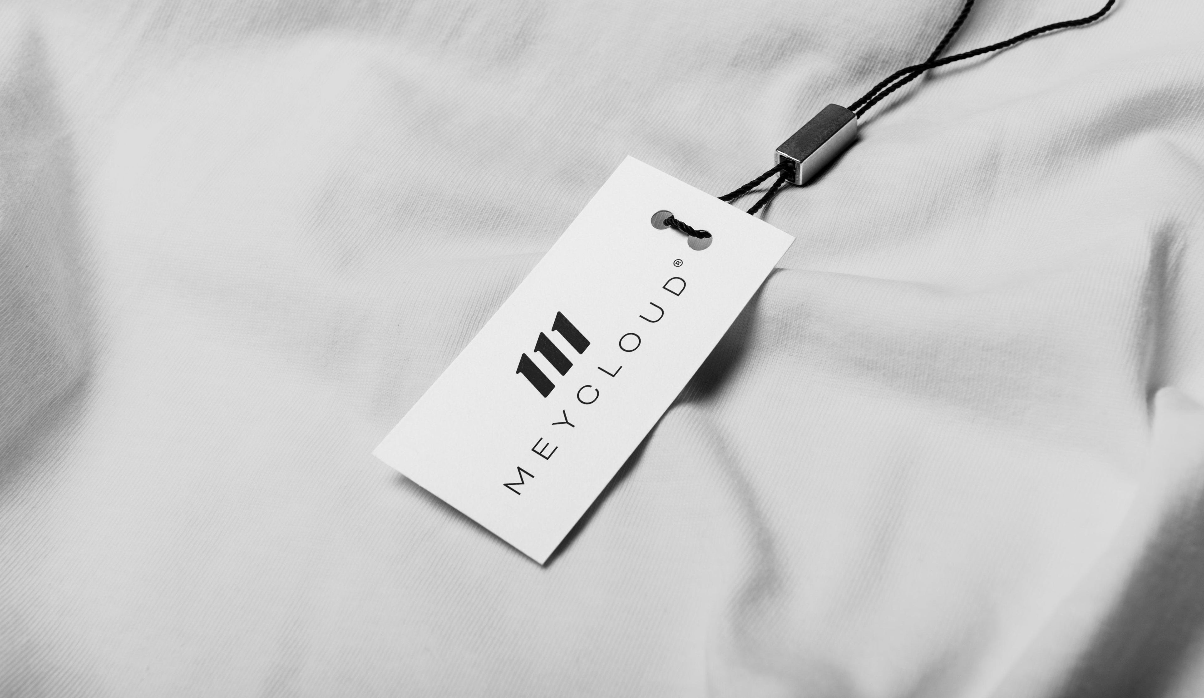 Close-up of Meycloud clothing tag with minimalist logo design, exemplifying luxury branding.