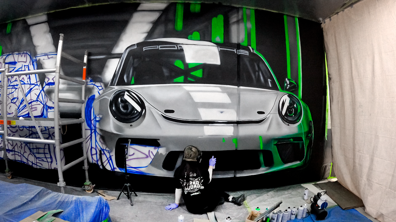 Large mural featuring a Porsche and a VW Golf with green accents, part of Tiana Kaiserfeld's Murals and Art Commissions Portfolio. This portfolio includes custom large-scale murals and personalized art pieces, designed to enhance commercial and personal spaces.